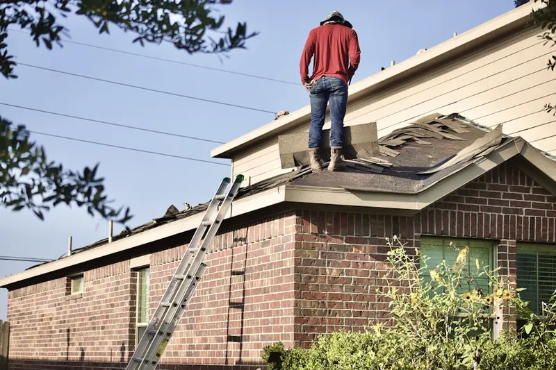 Professional roofer working on a residential roof in Highland Meadows
